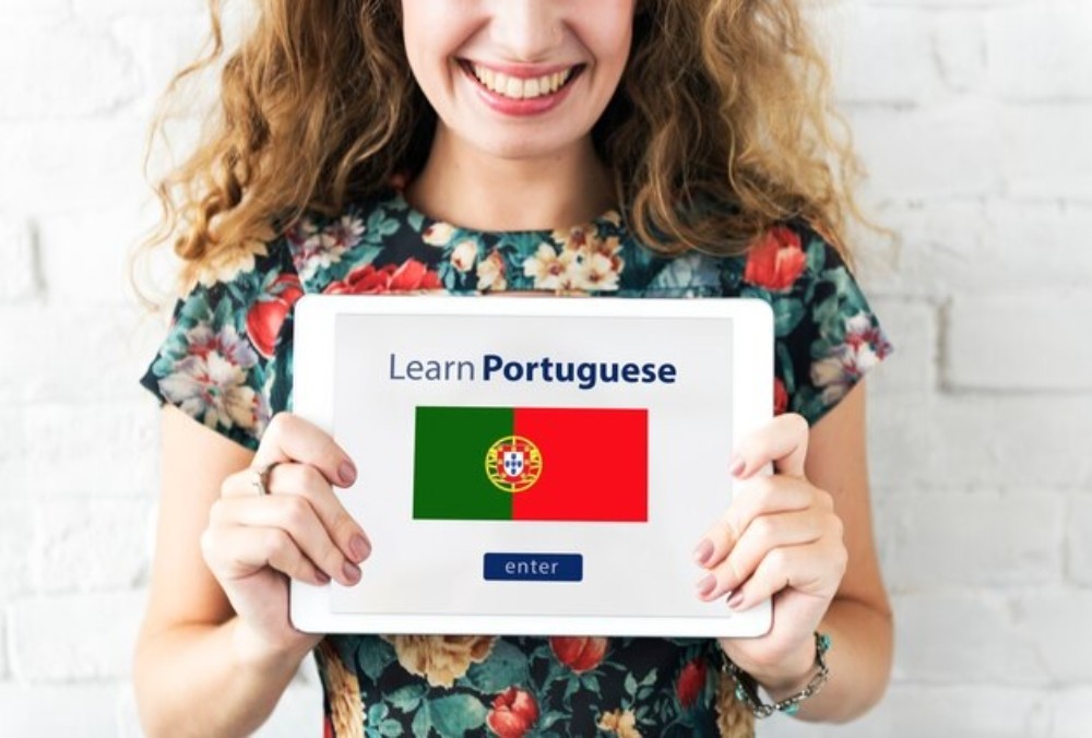 woman holding learn portuguese sign